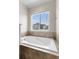 Bright soaking tub set beneath a window provides a relaxing space at 17857 Lapis Ct, Monument, CO 80132