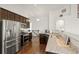 Modern kitchen with stainless steel appliances, granite countertops, and dark wood cabinetry and hardwood floors at 17857 Lapis Ct, Monument, CO 80132