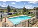 Community pool surrounded by black metal fencing and views of the mountains in the background at 645 Manhattan Pl # 106, Boulder, CO 80303