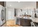 Modern kitchen featuring stainless steel appliances, a spacious island with stone countertops, and hardwood floors at 4539 Tennyson St # 105, Denver, CO 80212