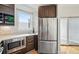 Contemporary kitchen with stainless steel refrigerator, dark wood cabinets, and ample natural light from the window at 4539 Tennyson St # 105, Denver, CO 80212
