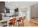 Modern kitchen with stainless steel appliances, quartz countertops, and island seating with hardwood floors at 4539 Tennyson St # 105, Denver, CO 80212