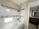 Modern bathroom showcasing a tiled bathtub with updated fixtures, along with an adjacent vanity area at 4312 S Xenon St, Morrison, CO 80465