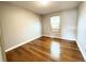 A cozy bedroom featuring gleaming hardwood floors, neutral walls, and a window with blinds at 4312 S Xenon St, Morrison, CO 80465