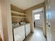 Convenient laundry room equipped with shelving and tile flooring at 4312 S Xenon St, Morrison, CO 80465