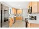 Well-lit kitchen with stainless steel appliances, quartz countertops, and light wood cabinetry, offering a blend of style and functionality at 9101 Clarkson St, Thornton, CO 80229