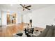 Open-concept living room with hardwood floors, stylish decor, and bright kitchen at 9101 Clarkson St, Thornton, CO 80229