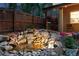 Rock water feature in a cozy backyard with outdoor grill on patio and string lights at 2250 N Monaco Pkwy, Denver, CO 80207