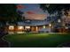 Exterior home view featuring a spacious backyard, patio, and outdoor seating at twilight at 2250 N Monaco Pkwy, Denver, CO 80207