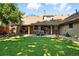 Expansive backyard featuring a covered patio, lush lawn, and well-maintained landscaping at 2250 N Monaco Pkwy, Denver, CO 80207