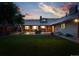 Backyard view showcasing the patio, outdoor seating, and expansive lawn with a fountain at 2250 N Monaco Pkwy, Denver, CO 80207