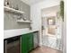 Stylish bar area with mini-fridge, patterned wallpaper, and floating shelves for storage at 2250 N Monaco Pkwy, Denver, CO 80207