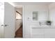 Modern bathroom features a white vanity and a stylish framed mirror, complemented by a door to another room at 2250 N Monaco Pkwy, Denver, CO 80207