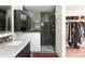 Stylish bathroom featuring a shower with dark tile, sleek vanity with granite countertop, and adjacent walk-in closet at 2250 N Monaco Pkwy, Denver, CO 80207