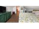 Bright bedroom with wood floors, sloped ceilings, and a green dresser for a modern look at 2250 N Monaco Pkwy, Denver, CO 80207