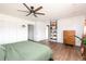 Bedroom featuring wood floors, a ceiling fan, and white walls, complemented by a view into an adjacent room at 2250 N Monaco Pkwy, Denver, CO 80207