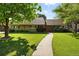 Charming single-story home features a well-manicured lawn, mature trees, and inviting front entry at 2250 N Monaco Pkwy, Denver, CO 80207