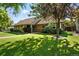 Inviting single-story home with lush green lawn and mature trees shading the front yard at 2250 N Monaco Pkwy, Denver, CO 80207
