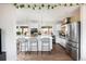 Modern kitchen with stainless steel appliances, white cabinetry, island with barstool seating at 2250 N Monaco Pkwy, Denver, CO 80207