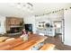 Open-concept living room with a brick fireplace and view into the updated kitchen at 2250 N Monaco Pkwy, Denver, CO 80207