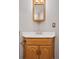 Small bathroom featuring a wood cabinet with a sink, mirror, and stylish fixtures at 20481 E Mansfield Pl, Aurora, CO 80013