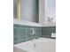 Close up on bathtub featuring green tiling, chrome faucet and a window with blinds at 20481 E Mansfield Pl, Aurora, CO 80013