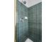 Walk-in shower featuring green tiled walls, a shower head, and a soap dish at 20481 E Mansfield Pl, Aurora, CO 80013