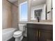 Well-lit bathroom with tub, toilet and vanity with dark wood cabinet and tile backsplash at 14265 Currant St, Broomfield, CO 80020