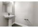 Modern half-bathroom with white pedestal sink, dark accents, and hexagon tile at 14265 Currant St, Broomfield, CO 80020
