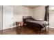 Simply designed bedroom with hardwood floors and a small side table at 5001 W Nevada Pl, Denver, CO 80219