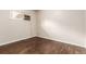 A well-lit bedroom features dark wood floors and a window AC unit at 5001 W Nevada Pl, Denver, CO 80219