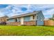 A cozy, light-blue home shows off its well-kept front lawn and decorative stone siding at 5001 W Nevada Pl, Denver, CO 80219