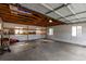 Large garage featuring exposed wood beams and a concrete floor at 5001 W Nevada Pl, Denver, CO 80219