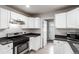 Efficient kitchen with stainless steel appliances, white cabinetry, and a gas range at 5001 W Nevada Pl, Denver, CO 80219