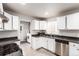 Functional kitchen with white cabinets, stainless steel appliances, and tiled flooring at 5001 W Nevada Pl, Denver, CO 80219