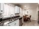 Open kitchen and dining area, featuring stainless steel appliances and white cabinetry at 5001 W Nevada Pl, Denver, CO 80219