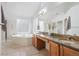 Bright bathroom featuring tile flooring, a dual-sink vanity, soaking tub, and glass enclosed shower at 12942 Leyden St, Thornton, CO 80602