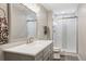 Modern bathroom with white vanity, new fixtures, large mirror, and tiled shower at 12942 Leyden St, Thornton, CO 80602