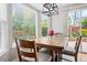 Inviting breakfast nook features a wooden table set, modern light fixture and views of a beautifully landscaped yard at 12942 Leyden St, Thornton, CO 80602