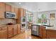 Well-appointed kitchen boasts stainless appliances, granite counters, and a dining area with backyard views at 12942 Leyden St, Thornton, CO 80602