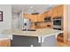Stylish kitchen showcases light wood cabinetry, stainless steel appliances, and a sizable center island with granite countertop at 12942 Leyden St, Thornton, CO 80602