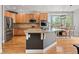 Bright kitchen with stainless appliances, hardwood floors, granite island with seating, and adjacent breakfast nook at 12942 Leyden St, Thornton, CO 80602