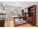 Home office with wood desk, built-in shelves, and a large window, creating a functional and stylish workspace at 12942 Leyden St, Thornton, CO 80602