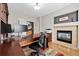 Comfortable home office featuring a fireplace, dark wood furnishings, and a dedicated workspace for productivity at 12942 Leyden St, Thornton, CO 80602