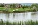 Calm community pond with walking path and picnic area in the background at 12942 Leyden St, Thornton, CO 80602