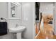 Charming powder room with pedestal sink; the photo offers a glimpse into the adjacent kitchen at 12942 Leyden St, Thornton, CO 80602