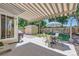 Relaxing covered patio with dining set, lush greenery, a wooden fence, and a storage shed at 7933 Florado St, Denver, CO 80221