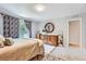 Comfortable bedroom with a plush bed, dresser with round mirror, and ample natural light from the window at 7933 Florado St, Denver, CO 80221