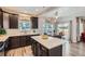 Modern kitchen with stainless steel appliances, dark cabinets, a quartz island, and stylish pendant lighting at 7933 Florado St, Denver, CO 80221