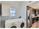 Laundry room with modern washer and dryer, cabinet and view into the kitchen at 7933 Florado St, Denver, CO 80221